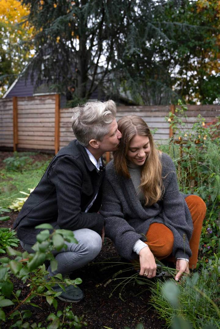 Un couple s'embrassant tout en jardinant dans leur jardin